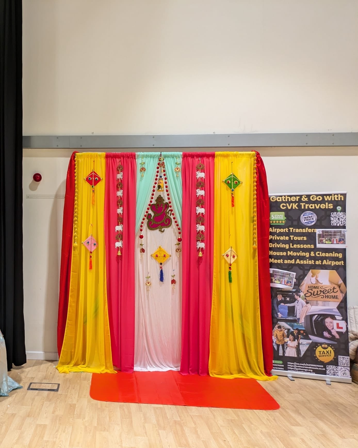 Red, yellow and mint drape backdrop with diya centrepiece