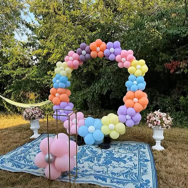 Pastel rainbow balloon flower wreath arch outdoors