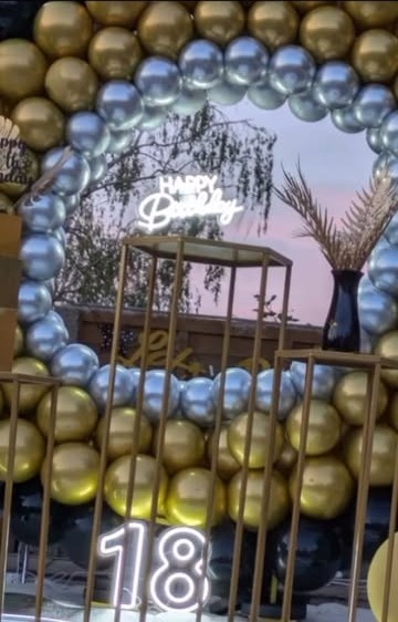 Gold and silver chrome balloon arch with neon Happy Birthday sign